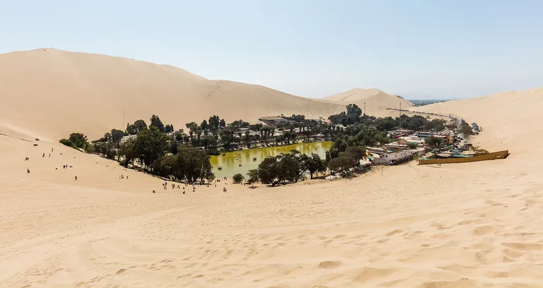 The Huacachina oasis surrounded by high desert dunes, Peru